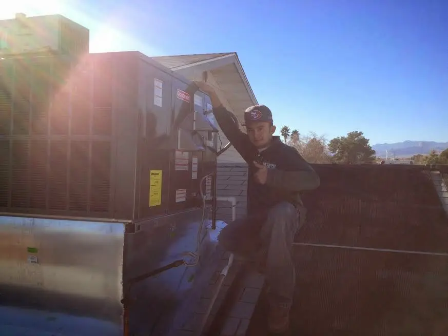 HVAC technician performing Air Duct Cleaning on a rooftop unit in Brewton
